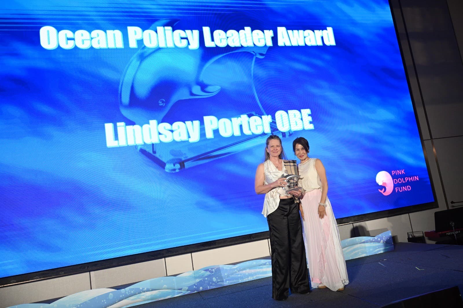 La Dra. Lindsay Porter OBE recibe su premio en el escenario.